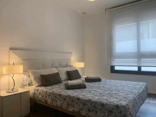 een slaapkamer met een groot bed en een raam bij Apartamento de lujo en primera linea de playa in Benidorm