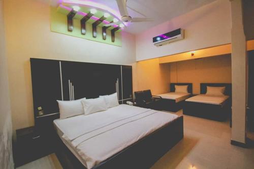 1 dormitorio con 1 cama blanca grande y escritorio en The R Hotels en Karachi