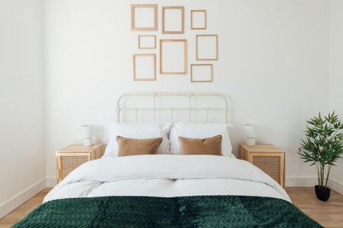 a bedroom with a white bed with a green blanket at Cosy 2 Bedroom Flat in Ilford, London in Ilford