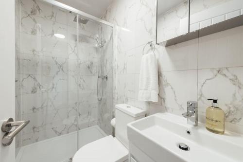 a white bathroom with a toilet and a sink at Cosy 2 Bedroom Flat in Ilford, London in Ilford