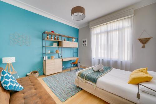 een slaapkamer met blauwe muren en een bed en een bureau bij La Maison ORE - Avec jardin in Bordeaux