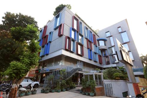 アナンドにあるHumming Bird Hotel & Banquetの街路面のカラフルな窓のある建物