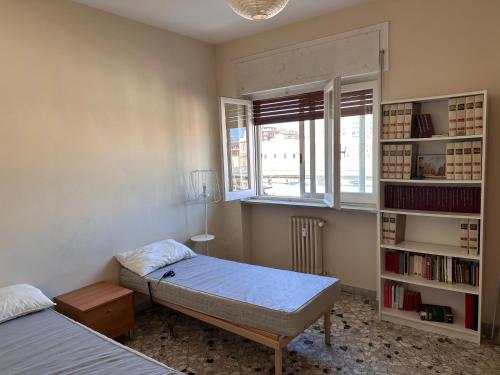 a bedroom with two beds and a book shelf at house green station in Bari