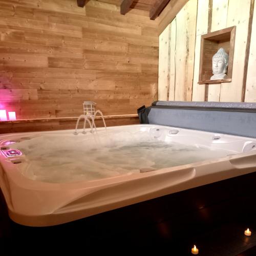 Cette chambre dispose de murs en bois et d'une baignoire. dans l'établissement La petite ferme, à La Chapelle