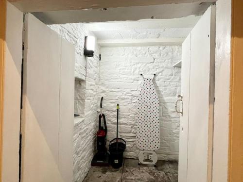 a room with a white brick wall and a doorway at 8 Standard Street by The Bear Hotel Crickhowell in Crickhowell