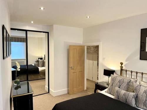 a bedroom with a bed and a room with a mirror at 8 Standard Street by The Bear Hotel Crickhowell in Crickhowell