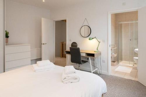um quarto branco com uma secretária e uma cama em Amazing and 3 bedroom house in Deptford em Londres