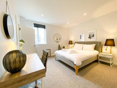 Schlafzimmer mit einem Bett, einem Tisch und einem Schreibtisch in der Unterkunft Amazing and 3 bedroom house in Deptford in London