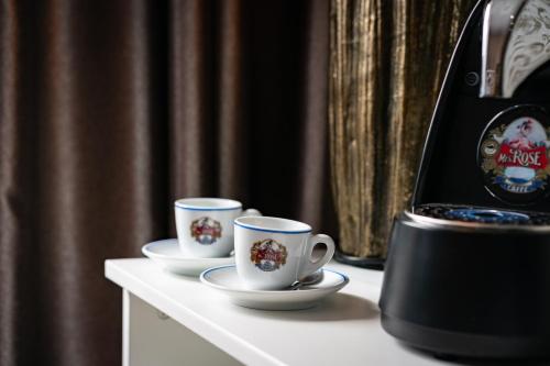 two cups on a table next to a coffee machine at Hotel Fontána in Brno