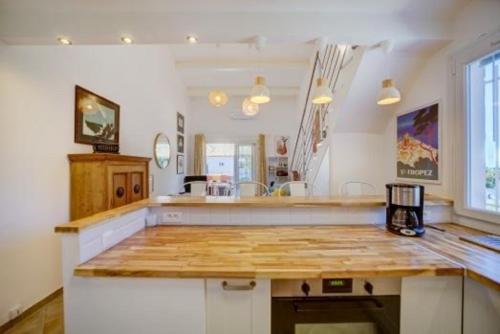 une cuisine avec un comptoir en bois dans une pièce dans l'établissement Très bel appartement Climatisé Terrasse et Vue Mer, à Bandol