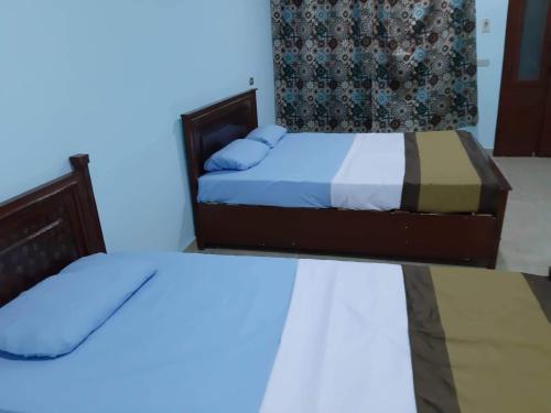 two beds in a room with blue lights at Nile Roof Hotel& Restaurant in Luxor