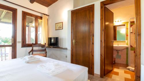 a bedroom with a bed and a bathroom with a sink at Sa Mola in Bonarcado