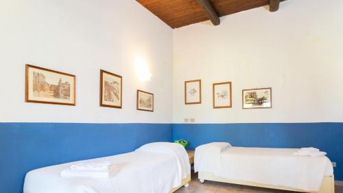 two beds in a room with blue and white walls at Sa Mola in Bonarcado
