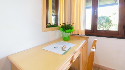 a wooden desk with a vase of flowers on it at Sa Mola in Bonarcado