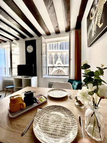 - une table à manger avec des assiettes au-dessus dans l'établissement Appartement Vue Cathédrale- Centre ville Meaux-Gare-Disney, à Meaux