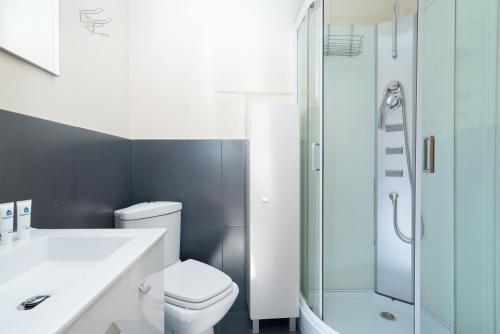 a bathroom with a white toilet and a shower at Magnificent Sunny Flat - Douro River in Vila Nova de Gaia
