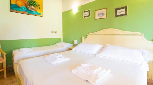 two twin beds in a room with green walls at Sa Mola in Bonarcado
