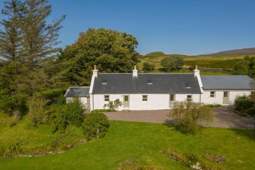 an aerial view of a white house on a hill at Portree, Isle of Skye in Portree