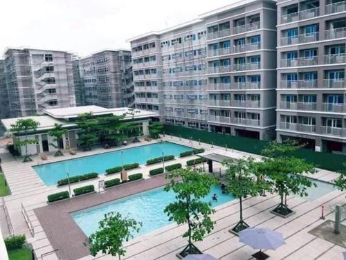a large swimming pool in front of a building at Osam Empire Studio 1 @Trees Residences in Manila