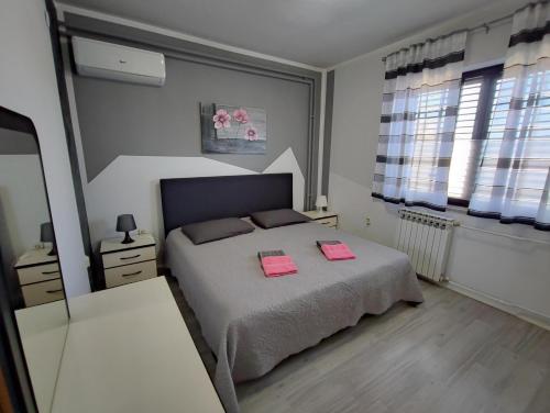 1 dormitorio con 1 cama con 2 toallas rosas en Apartment Ari, en Rovinj