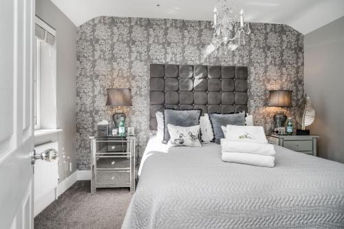 a bedroom with a large bed with a large headboard at Newmarket Boutique Apartments in Newmarket