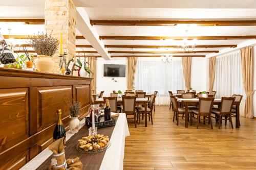 a restaurant with tables and chairs in a room at Pensiunea Popas in Apuseni in Răchiţele