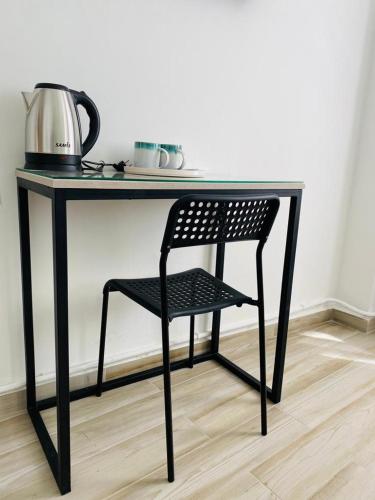 a black desk with a chair and a tea kettle at Arabesque Hotel in Amman