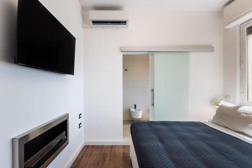 a bedroom with a bed and a flat screen tv on a wall at Mansarda Aurispa in Noto