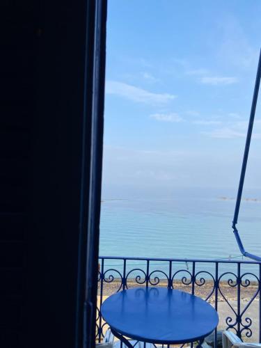 a table on a balcony with a view of the ocean at Hotel Areti in Aegina Town
