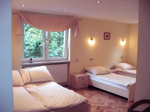1 dormitorio con 2 camas y ventana en Apartamenty Kubalonka en Istebna