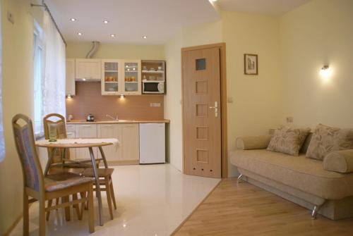 ein Wohnzimmer mit einem Sofa und einem Tisch sowie eine Küche in der Unterkunft Apartamenty Kubalonka in Istebna