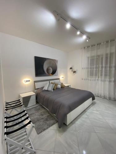 ein Schlafzimmer mit einem großen Bett in einem weißen Zimmer in der Unterkunft Perla Diva Apartment in Palermo