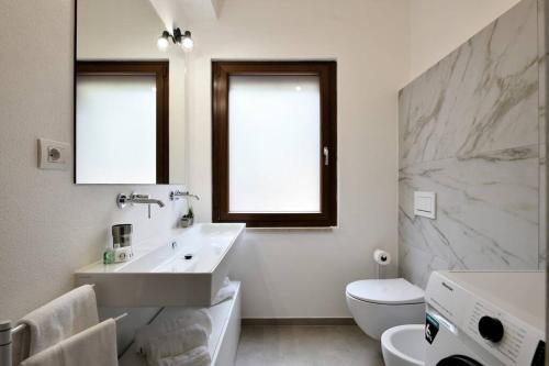 アルバタックスにあるAmazing view – Beautiful Apartment Portu Frailisの洗面台とトイレを備えた白いバスルーム