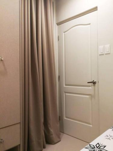 a white door with a curtain in a room at Adria Residences - Emerald Garden - 2 Bedroom Unit for 4 person in Manila