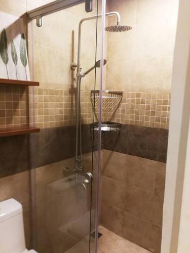 a shower with a glass door in a bathroom at Adria Residences - Emerald Garden - 2 Bedroom Unit for 4 person in Manila