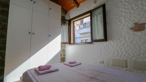 a bedroom with a bed with two pink towels on it at Welcomely - Sa Dommedda in Nuoro