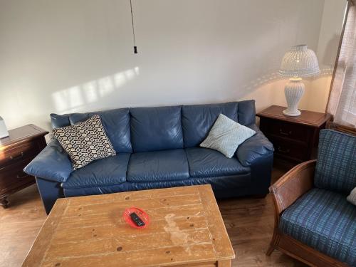un soggiorno con divano blu e tavolino da caffè di Sandy Mutts at the Beach cottage a North Camellia Acres