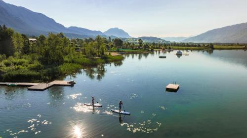 two people are on boats on a lake at Lake Resort Pressegger See in Hermagor