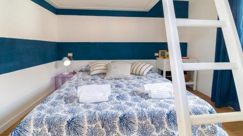 - une chambre dotée d'un lit bleu et blanc avec deux oreillers dans l'établissement Welcomely - Casa Dei Marinai, à Putzu Idu