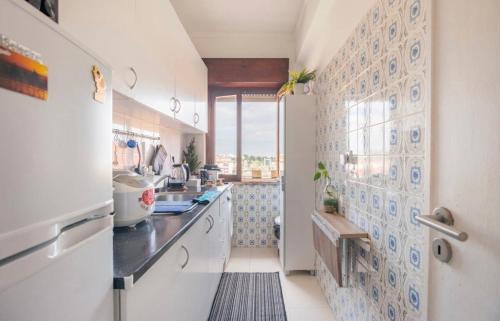 a kitchen with blue and white tiles on the wall at Cardia’s Guest House in Sacavém