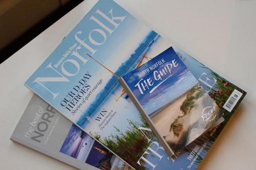 two magazines sitting on top of a table at Saving Grace with private hot tub in Bawdeswell