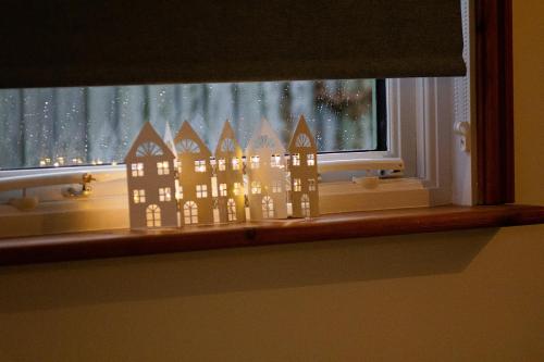 a window with a paper cut out of a castle at Saving Grace with private hot tub in Bawdeswell