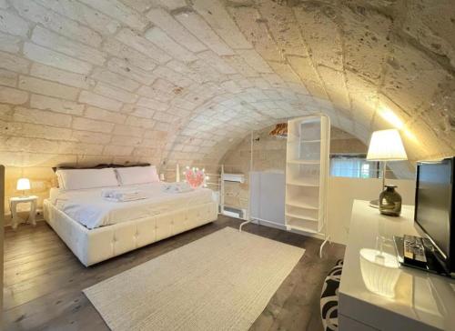 ナルドにあるCasa Dahliaの石壁のベッドルーム1室(大型ベッド1台付)