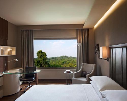 um quarto de hotel com uma cama, uma secretária e uma janela em Hyatt Regency Delhi em Nova Deli