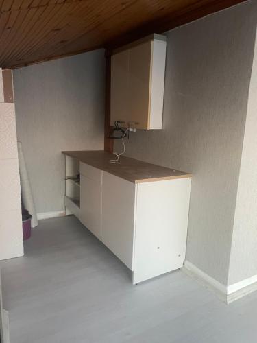 uma cozinha com um balcão branco e um armário em Suit tuzla em Tuzla