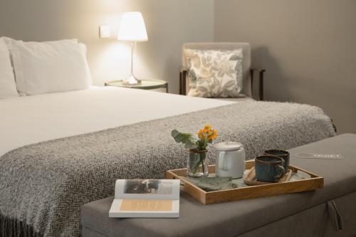 ein Bett mit einem Tablett mit einem Buch und Blumen darauf in der Unterkunft Hygge House in Lissabon