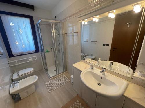 a bathroom with a sink and a shower and a mirror at Trilocale vista mare con 2 bagni nel centro storico - Agenzia Cocal in Caorle