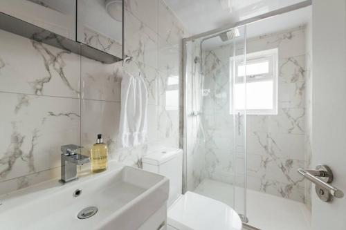 a white bathroom with a sink and a shower at Contemporary 1 Bedroom Loft in Ilford, London in Ilford