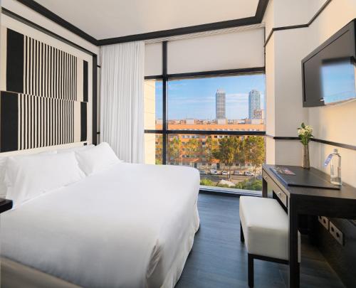 a hotel room with a bed and a desk and a window at H10 Marina Barcelona in Barcelona