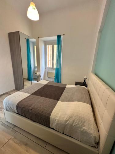 a bedroom with a large bed with blue curtains at Casa al Prino in Imperia